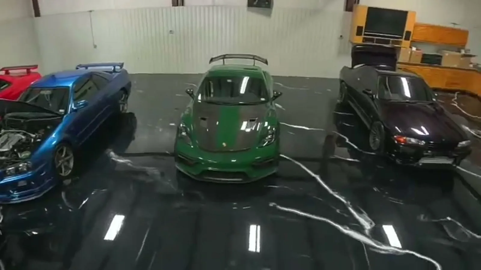 A finished dark metallic epoxy floor in a car garage with three sports cars parked on it